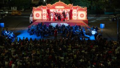 Veduta dallalto del camionteatro aperto che ospita Il barbiere di Siviglia con orchestra e cantanti e il pubblico seduto allaperto